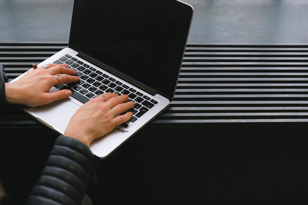 Close-up of hands typing on a sleek laptop, ideal for freelance work.