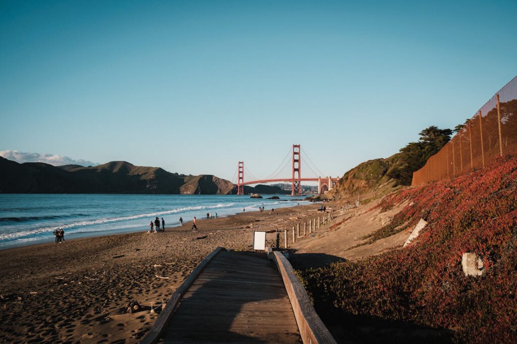 Scenic view of Golden Gate Bridge from beach with ocean and foothills, San Francisco.