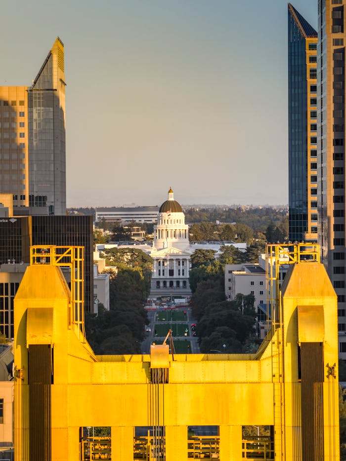 Aerial view of Sacramento's iconic Tower Bridge framing the California State Capitol at sunset.