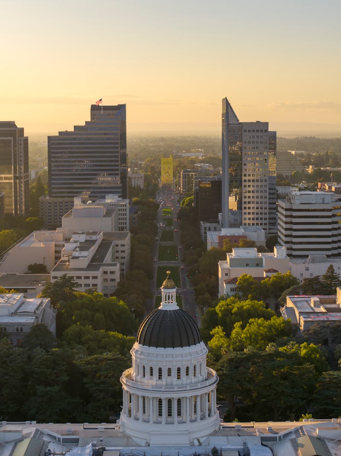 Aerial view of Sacramento skyline featuring the California Capitol and Tower Bridge at sunset.